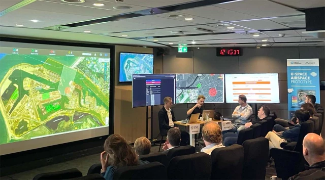 Presentation during the Port of Rotterdam’s U-space Airspace demonstration, showing digital maps and real-time airspace management tools on multiple screens, with speakers and attendees engaged in discussion.